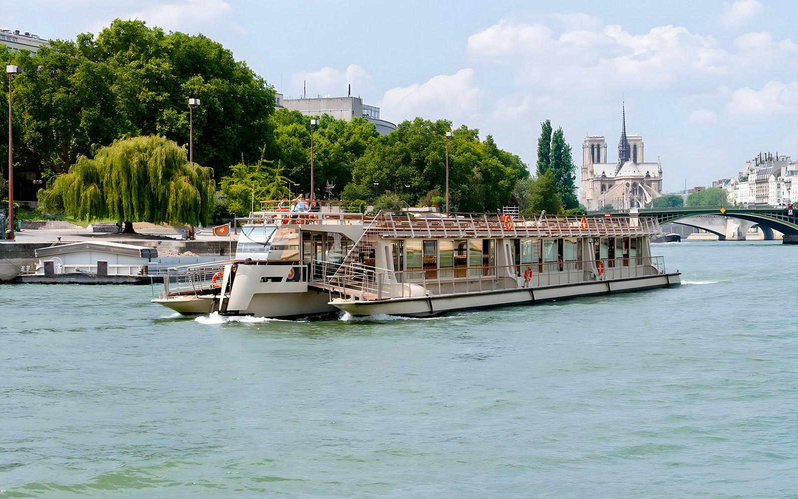 Seine River cruise boat near Notre-Dame Cathedral, Paris.