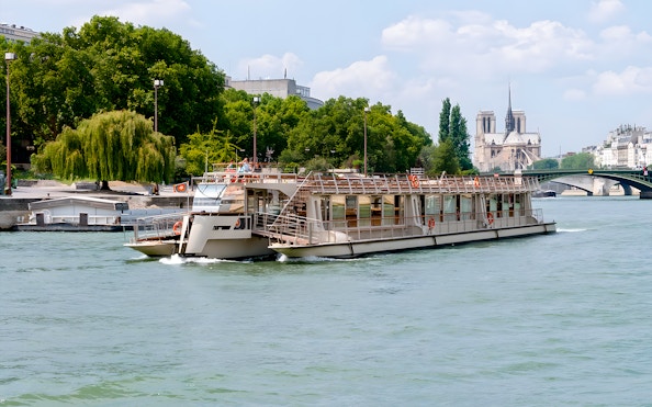Seine River cruise boat near Notre-Dame Cathedral, Paris.
