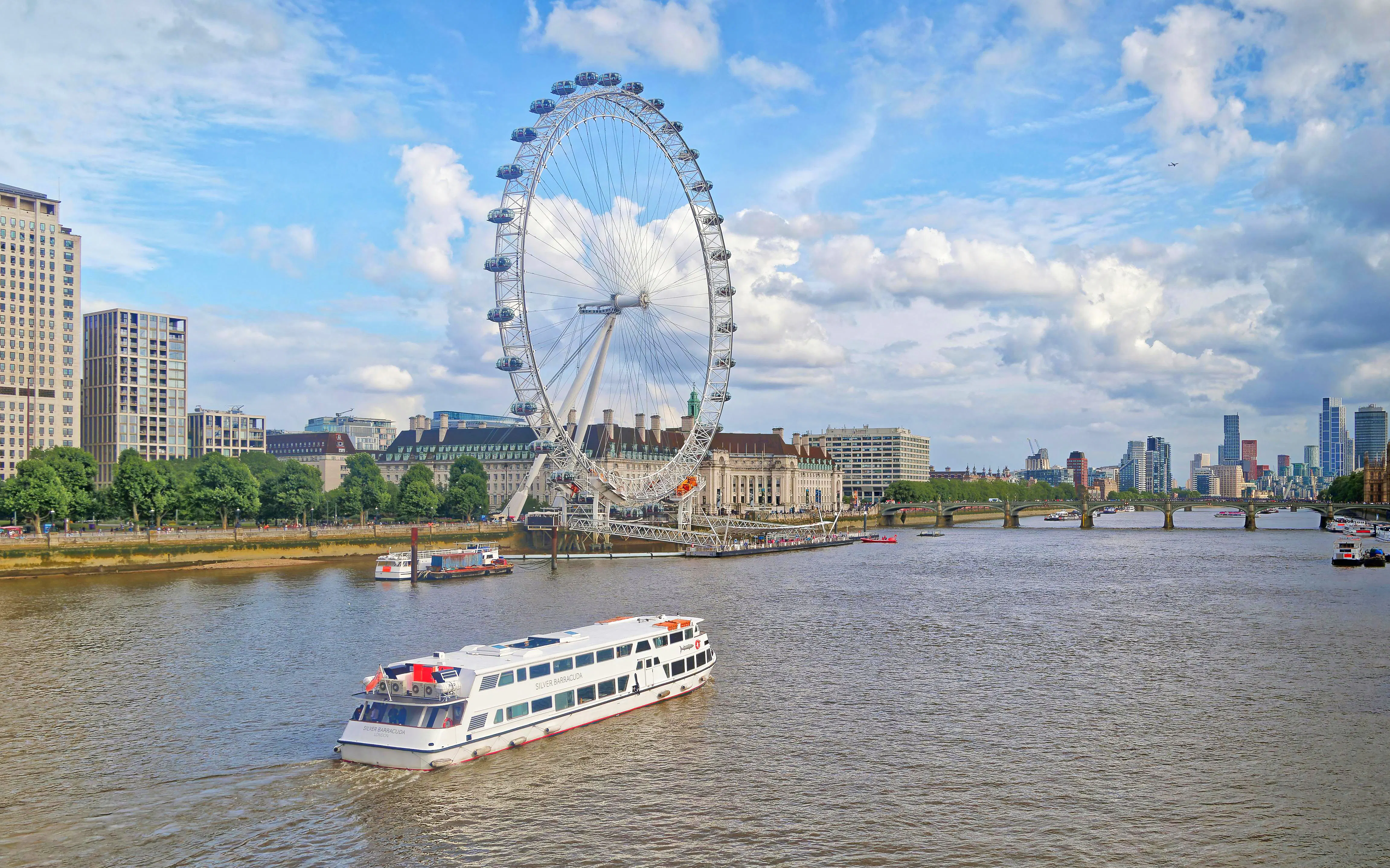 Cruise boat on River Thames with London Eye in the background, London.