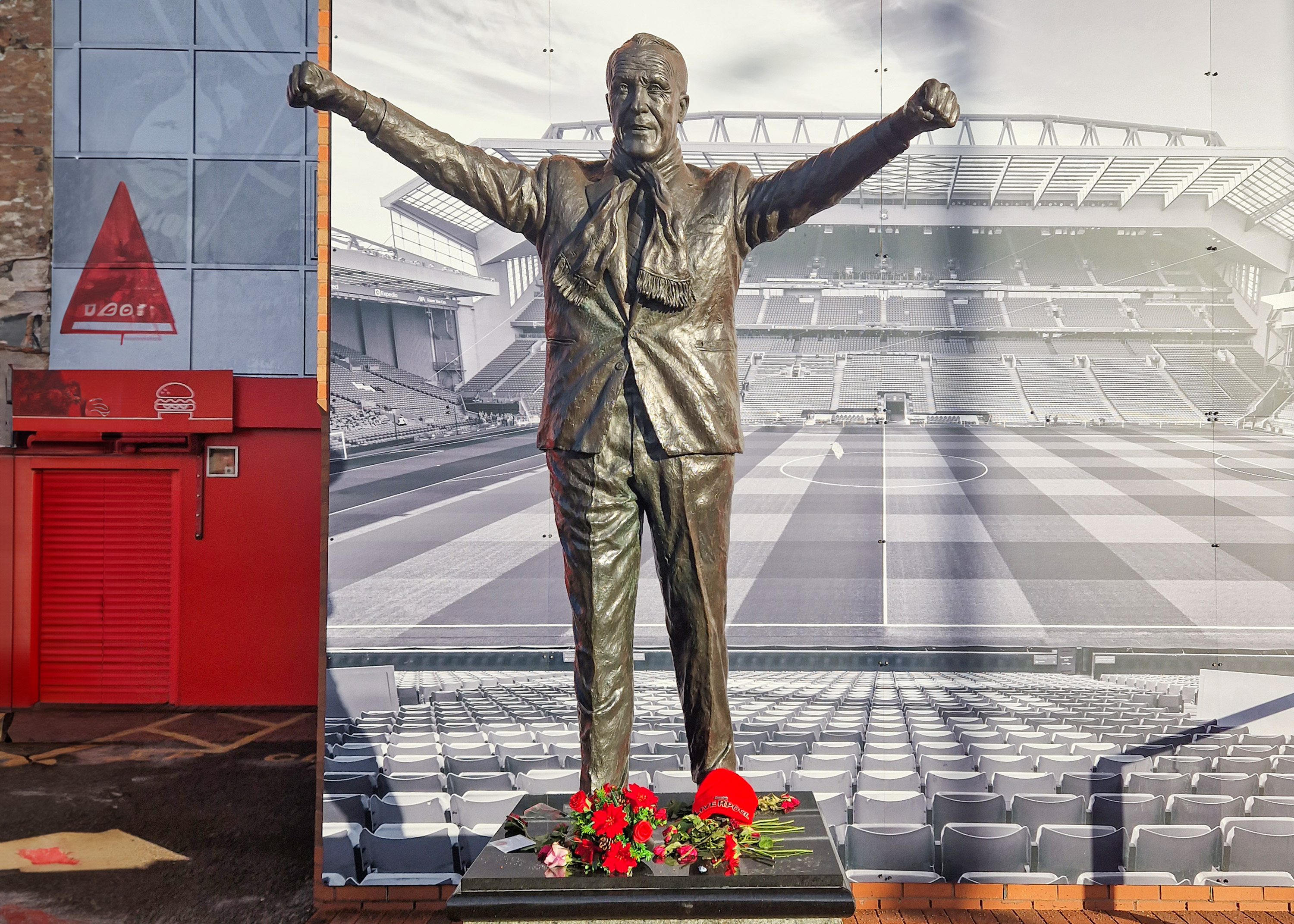 Liverpool FC stadium tour with view of Anfield pitch and iconic red seats.
