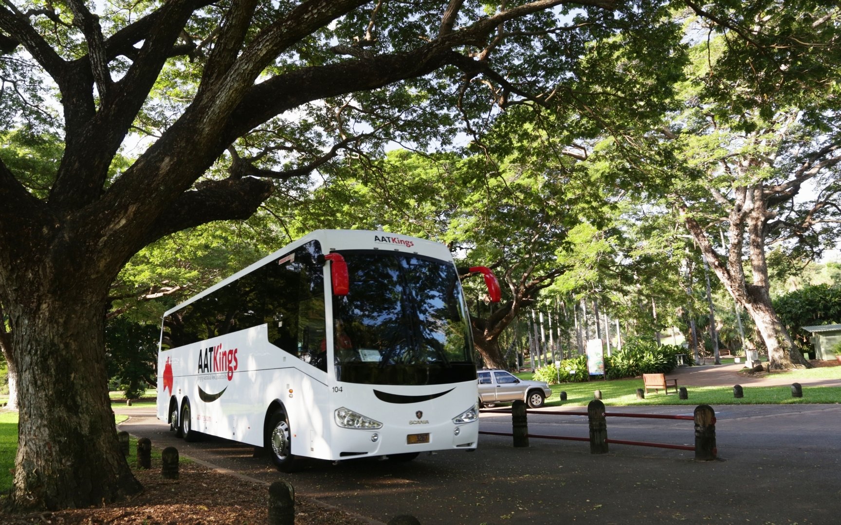 Tour bus parked under trees for Adelaide River Jumping Crocodile Cruise.