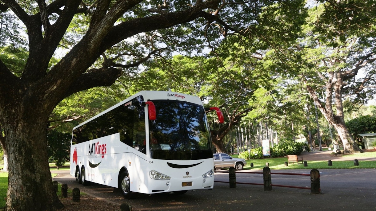 Tour bus parked under trees for Adelaide River Jumping Crocodile Cruise.