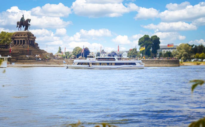 Koblenz sightseeing cruise passing Deutsches Eck monument on the Rhine River.