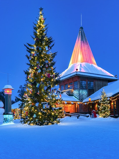 Christmas tree and illuminated building at Santa Claus Village, Rovaniemi, Finland.