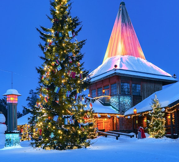 Christmas tree and illuminated building at Santa Claus Village, Rovaniemi, Finland.