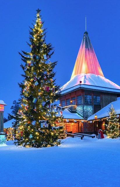 Christmas tree and illuminated building at Santa Claus Village, Rovaniemi, Finland.
