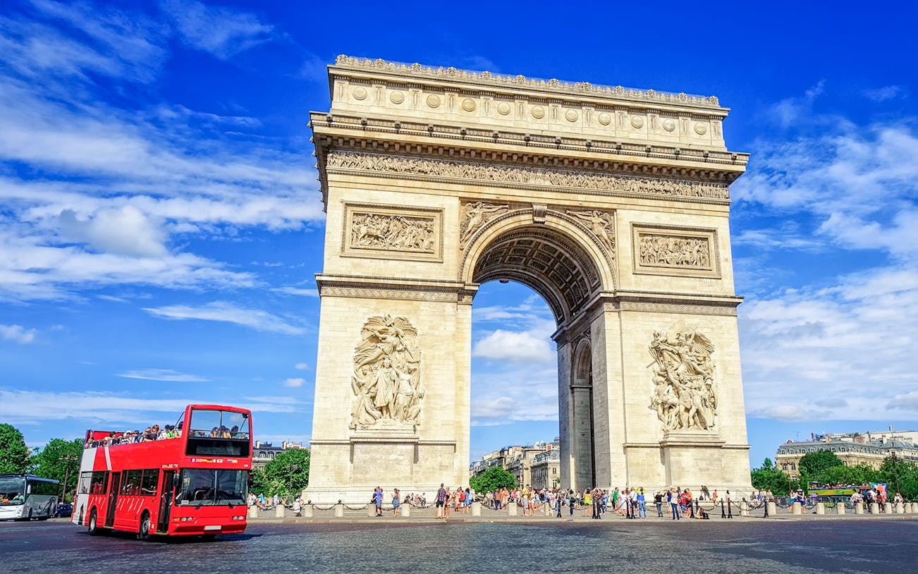 Arc de Triomphe with a red tour bus in Paris, part of the Paris in a Day Guided Tour.