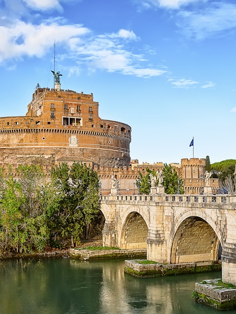 Castel Sant'Angelo and Sant'Angelo Bridge over Tiber River on a sunny day in Rome, Italy.