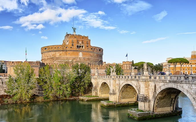 Castel Sant'Angelo and Sant'Angelo Bridge over Tiber River on a sunny day in Rome, Italy.