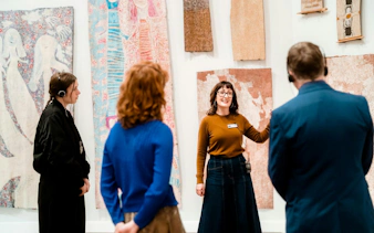 Tour guide explaining artwork to visitors at National Gallery of Victoria.