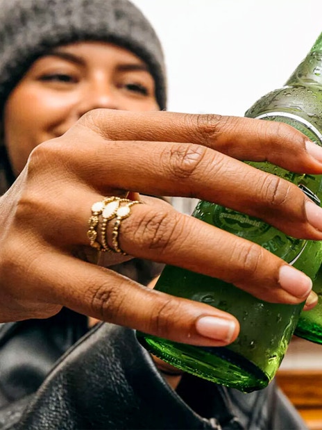 Guests toasting with Heineken bottles on Amsterdam canal cruise.
