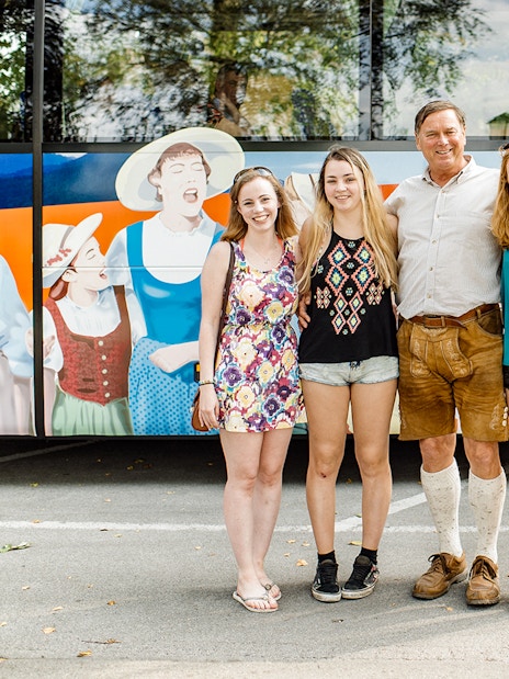 Tourists posing in front of the Original Sound of Music tour bus in Salzburg.