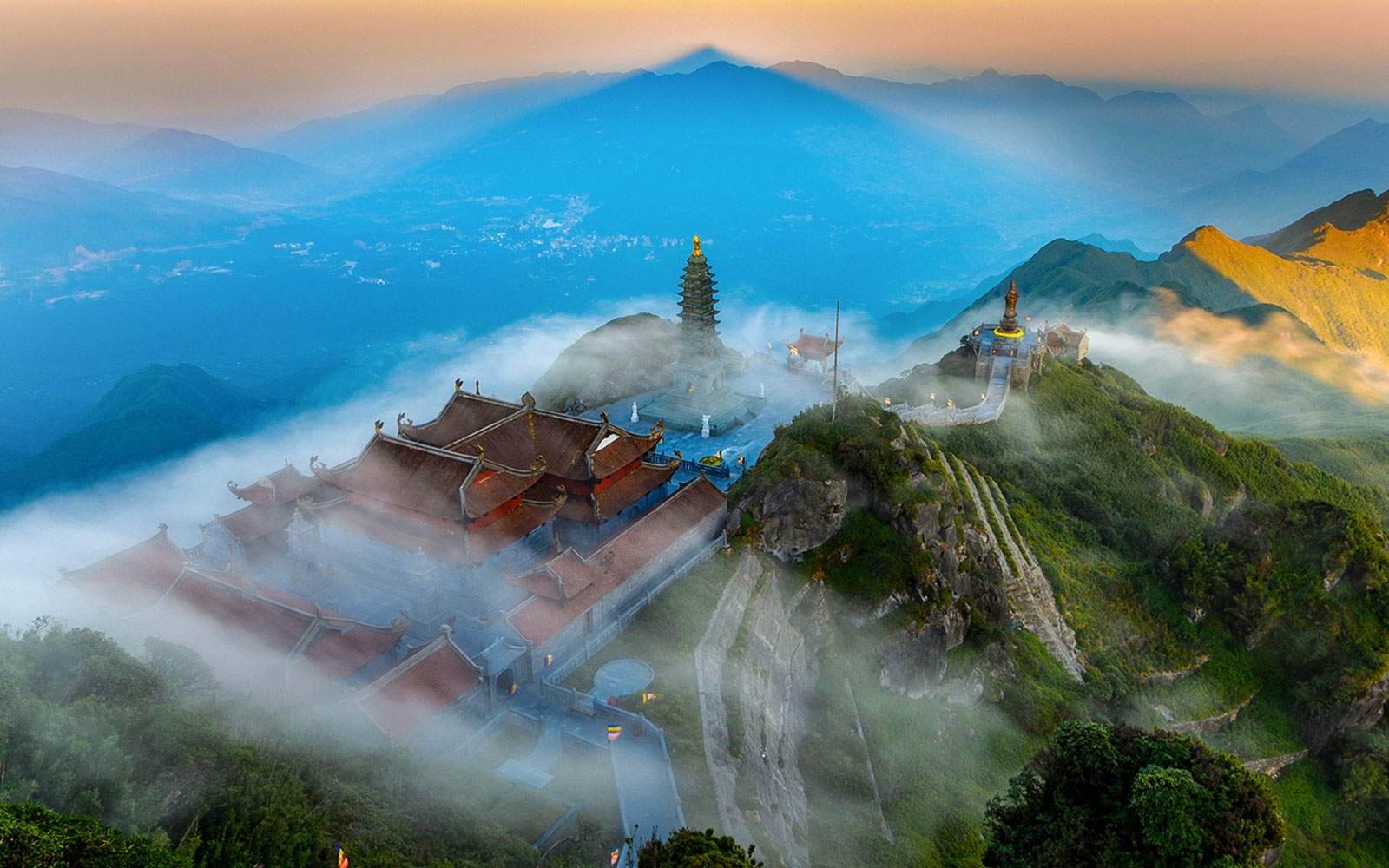 Sun World Fansipan Legend pagoda and statue surrounded by misty mountains in Vietnam.