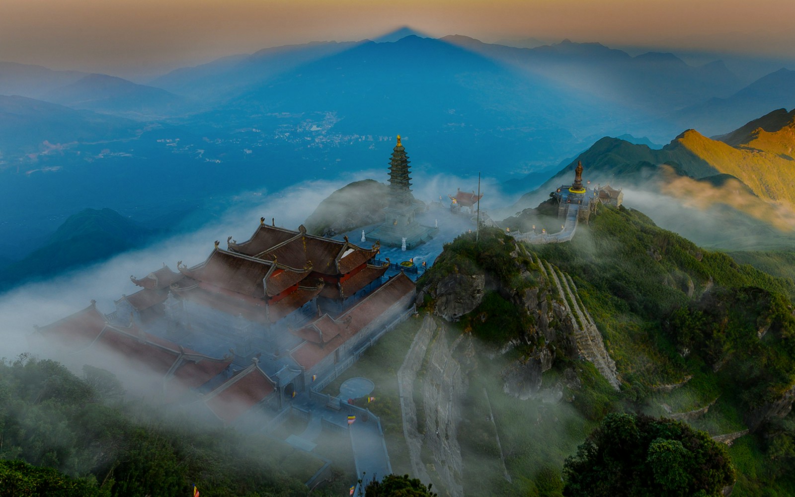 Sun World Fansipan Legend pagoda and statue surrounded by misty mountains in Vietnam.