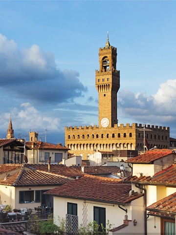 Palazzo Vecchio tower rising above Florence rooftops, Italy.