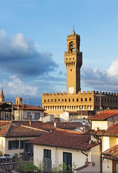 Palazzo Vecchio tower rising above Florence rooftops, Italy.