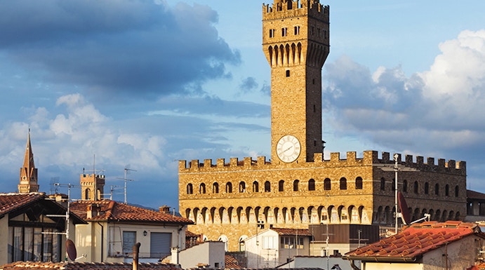 Palazzo Vecchio tower rising above Florence rooftops, Italy.