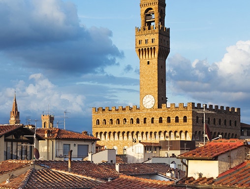 Palazzo Vecchio tower rising above Florence rooftops, Italy.