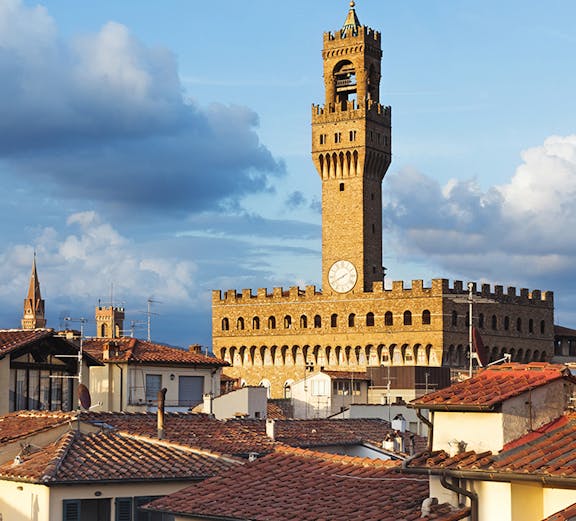 Palazzo Vecchio tower rising above Florence rooftops, Italy.