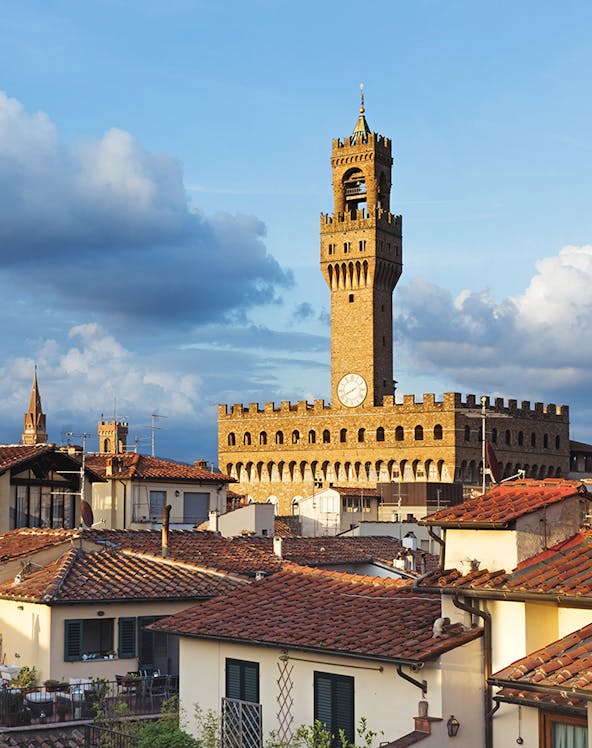 Palazzo Vecchio tower rising above Florence rooftops, Italy.