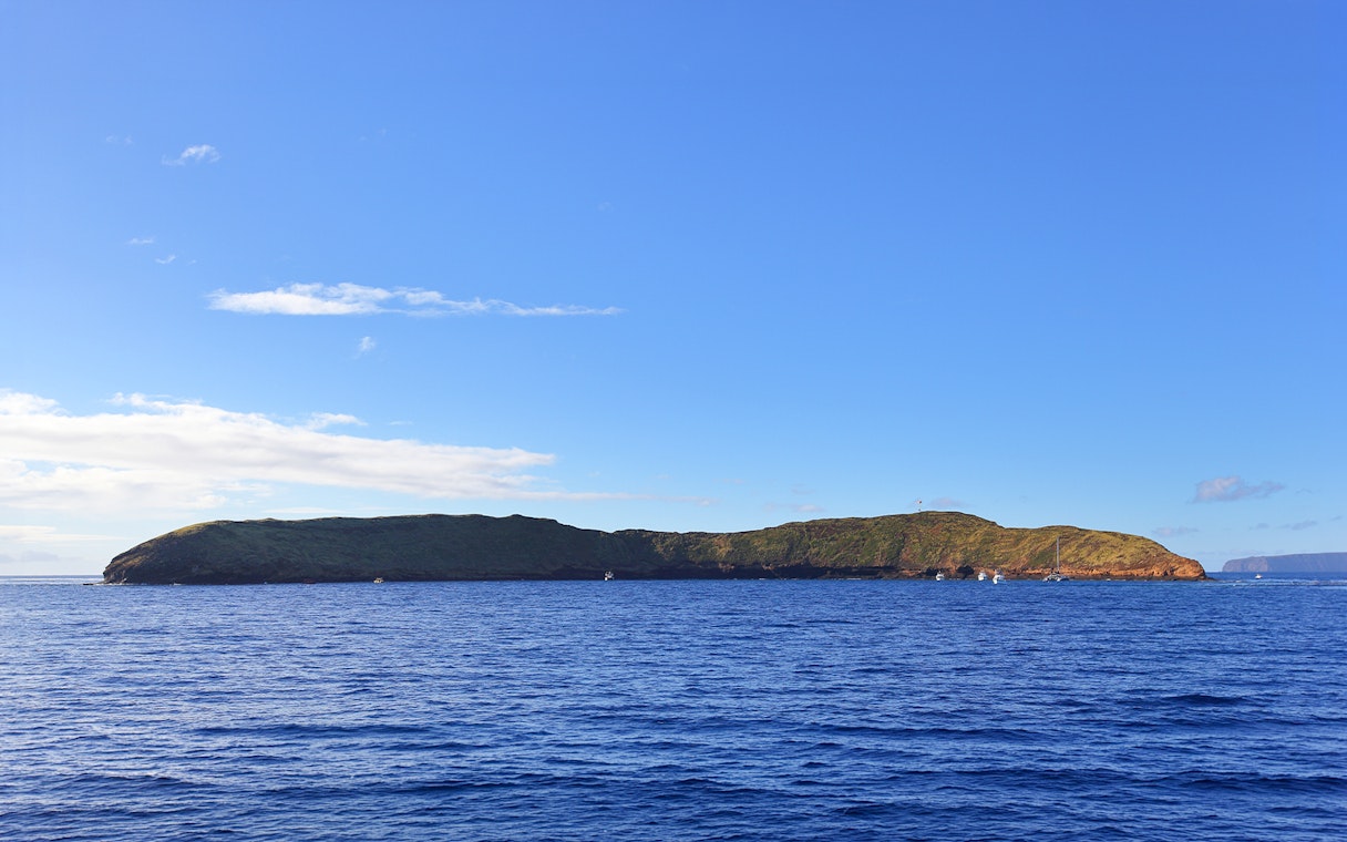 Molokini Crater in Maui, Hawaii, surrounded by blue ocean under a clear sky.
