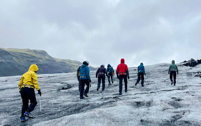 Guests hiking on Sólheimajökull Glacier in Iceland during a small group tour.