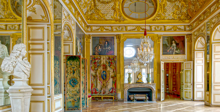 Kings apartment in Versailles Palace with ornate gold decor and marble bust.