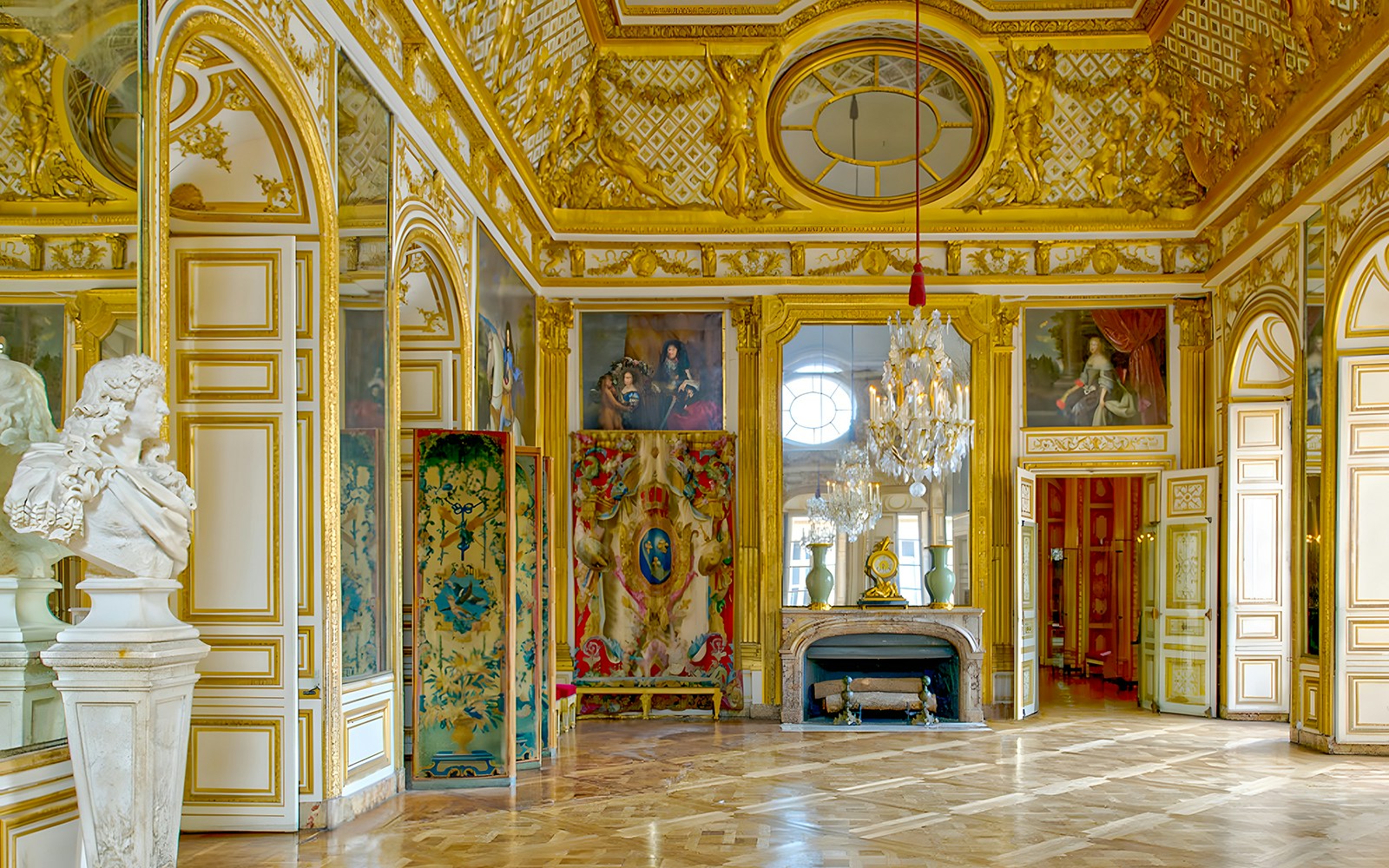 Kings apartment in Versailles Palace with ornate gold decor and marble bust.