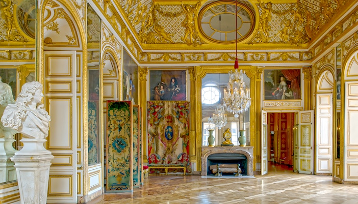 King's apartment interior, Versailles Palace, France, featuring ornate furnishings and intricate ceiling details.