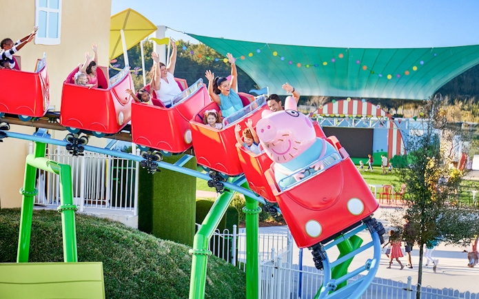 Kids and family enjoying mini rollercoaster at Peppa Pig Park, Guntzburg.