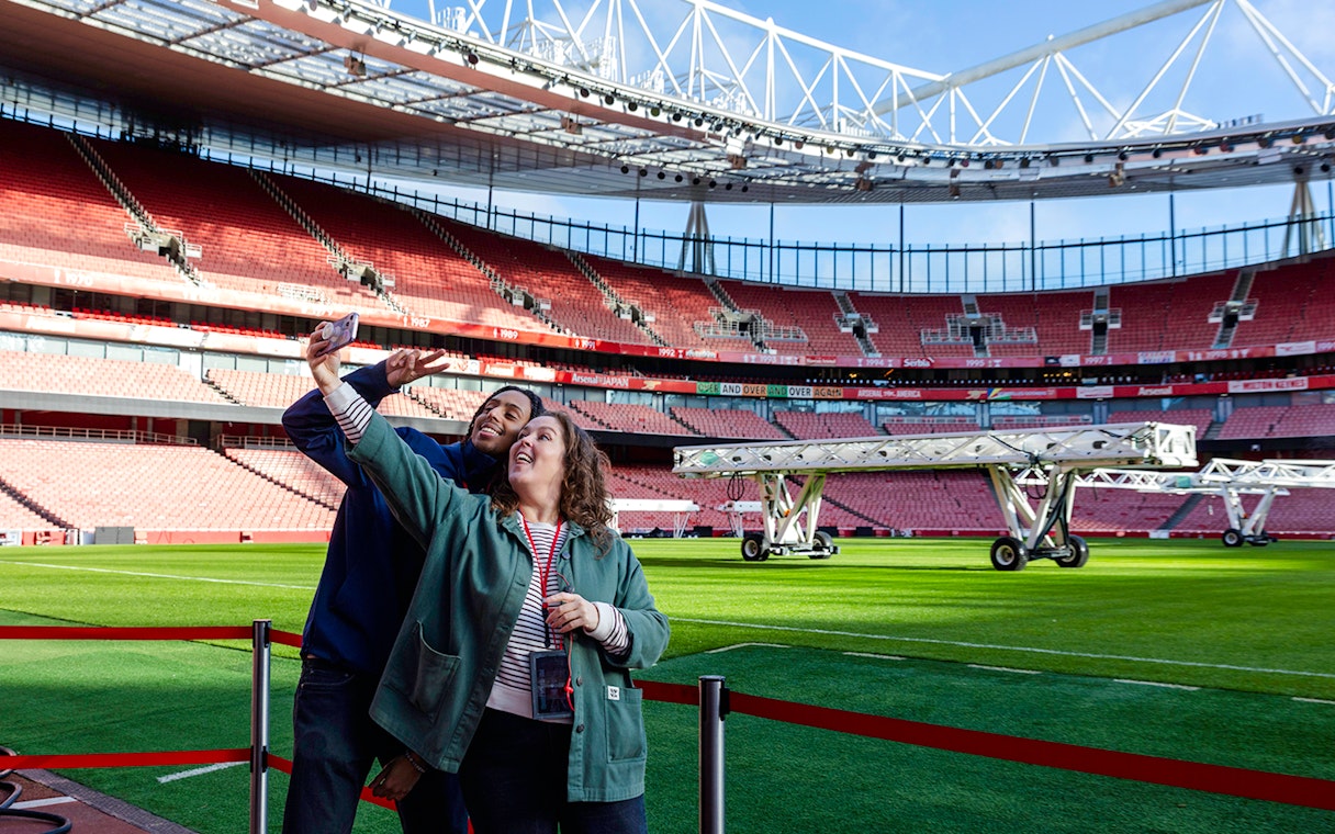 Guests taking a selfie by the pitch side at Emirates Stadium.