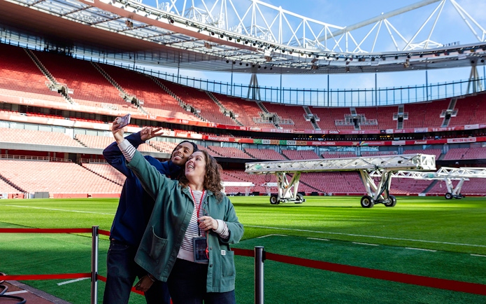 Guests taking a selfie by the pitch side at Emirates Stadium.
