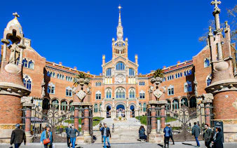 Sant Pau Moderniste Site entrance in Barcelona with visitors walking.