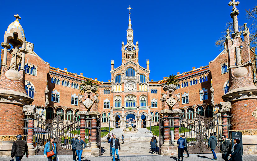 Sant Pau Moderniste Site entrance in Barcelona with visitors walking.