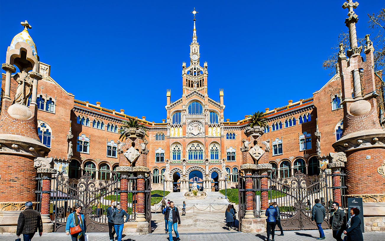 Sant Pau Moderniste Site entrance in Barcelona with visitors walking.