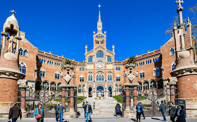 Sant Pau Moderniste Site entrance in Barcelona with visitors walking.