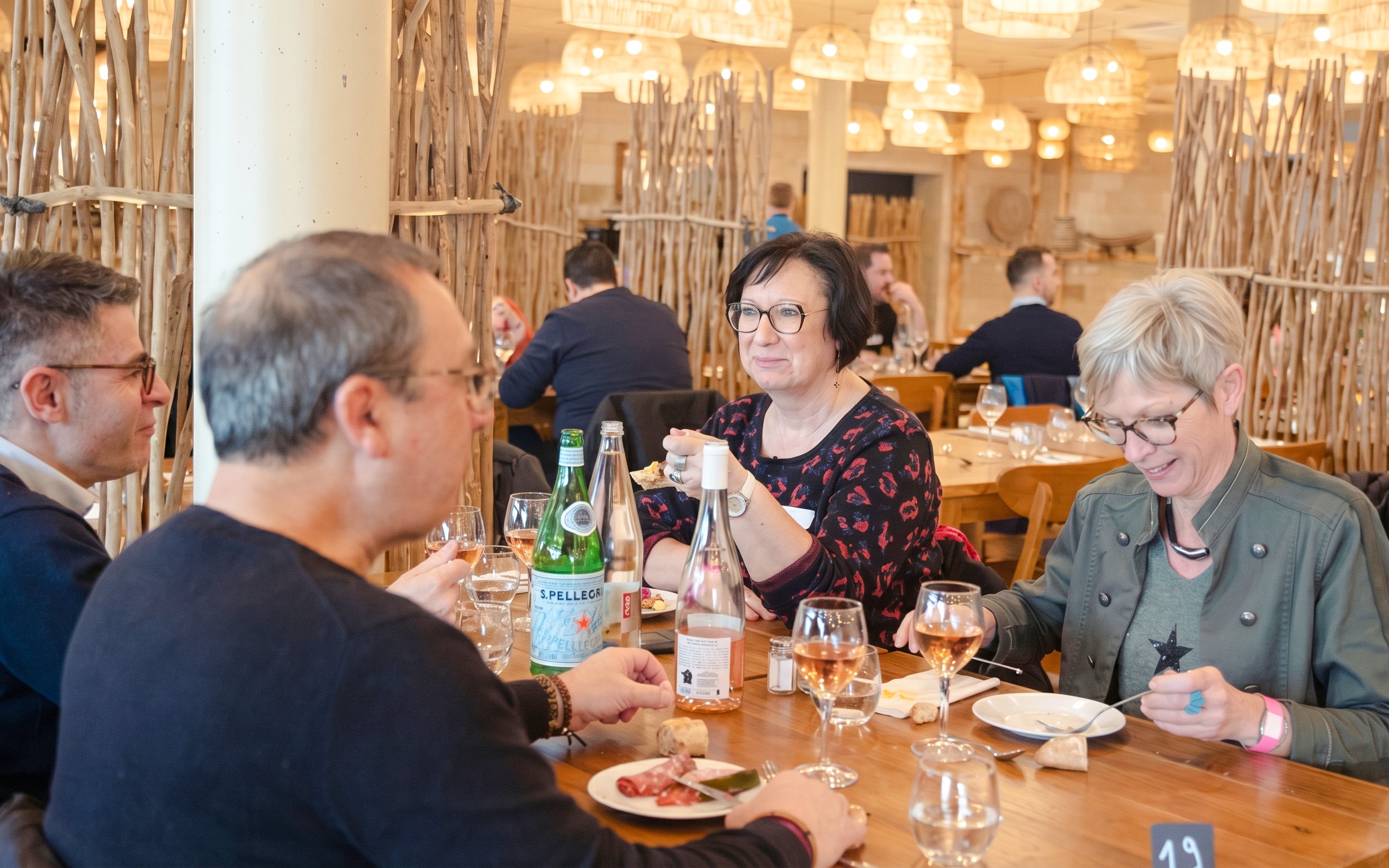Dining experience at ZooParc de Beauval with guests enjoying a meal at a wooden table.