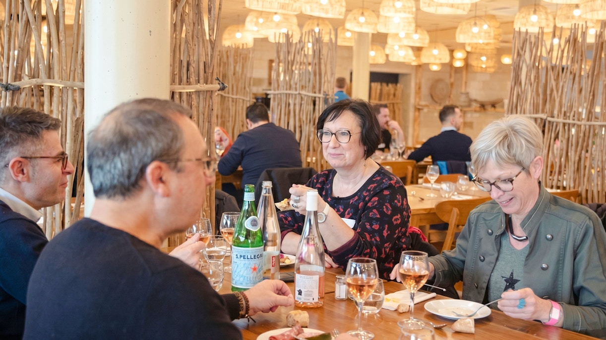 Dining experience at ZooParc de Beauval with guests enjoying a meal at a wooden table.