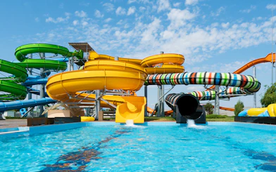 Water slides at Aqualand in Albufeira with colorful tubes and splash pool.