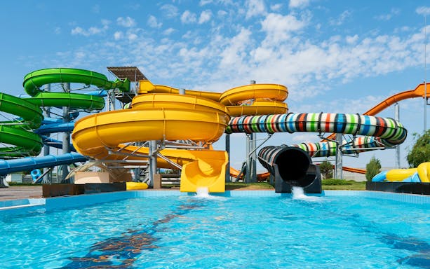 Water slides at Aqualand in Albufeira with colorful tubes and splash pool.