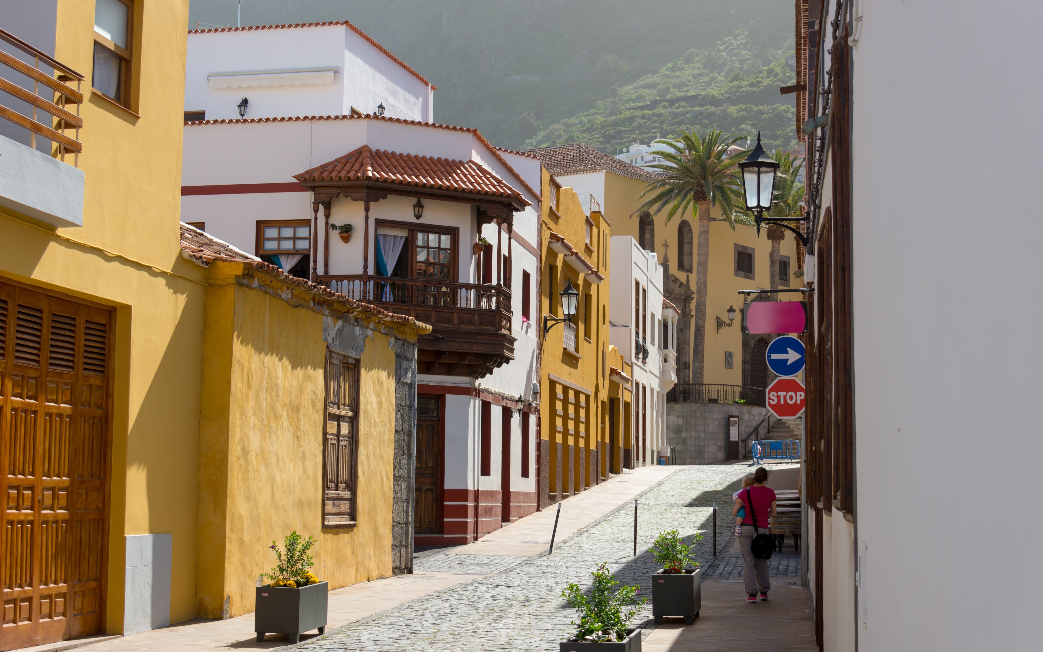 Traditional Spanish architecture on a cobblestone street in Tenerife coastal town.