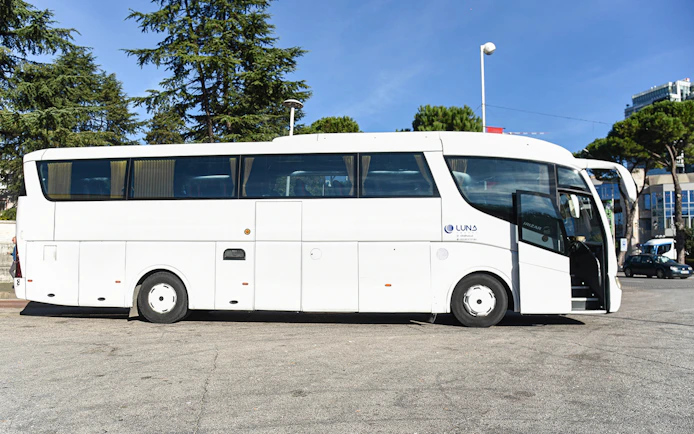 Bus for Tirana Airport transfer service parked at a station.