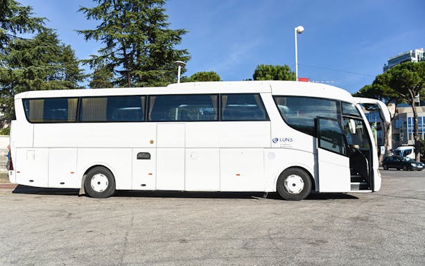 Bus for Tirana Airport transfer service parked at a station.