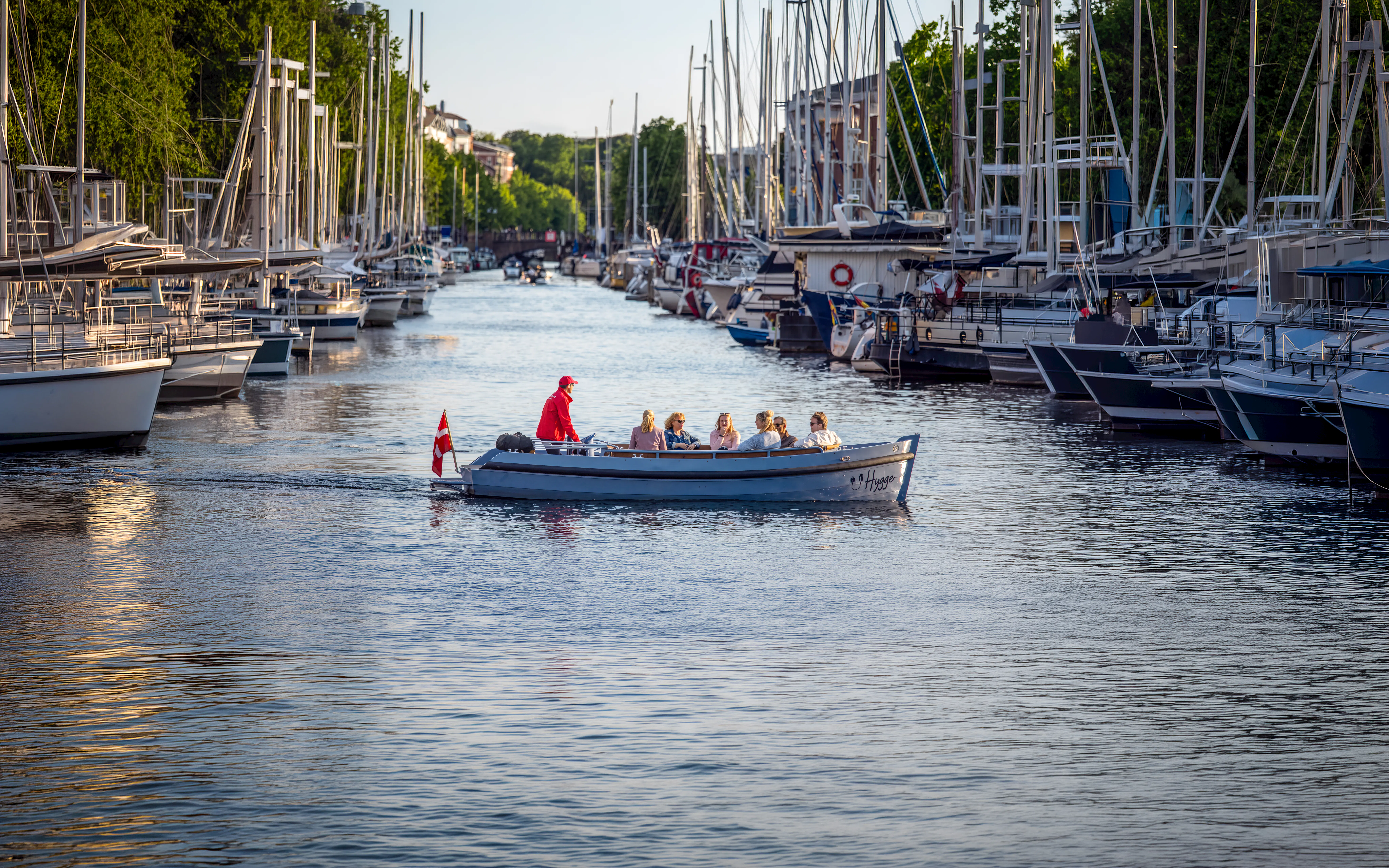 Canal boat tour in Copenhagen with passengers enjoying the view from Ved Stranden.