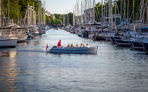 Canal boat tour in Copenhagen with passengers enjoying the view from Ved Stranden.