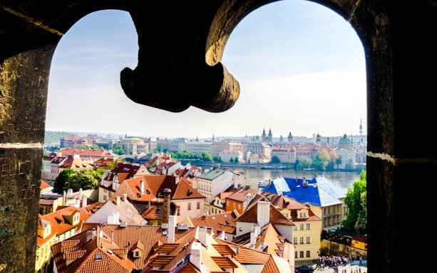 View of Prague's Lesser Town rooftops and Vltava River from Charles Bridge Tower.