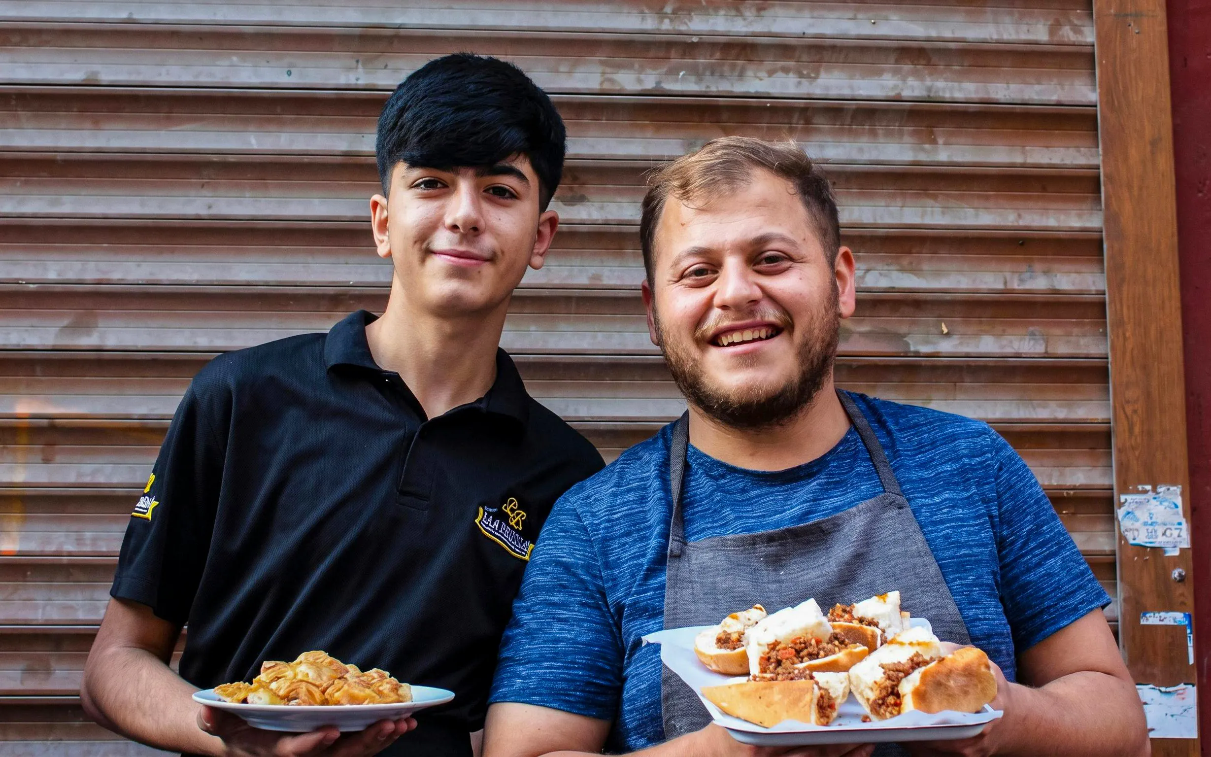 Two men holding plates of traditional Turkish food on an Istanbul food tour.