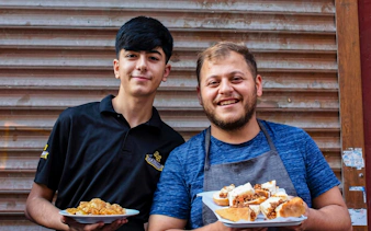 Two men holding plates of traditional Turkish food on an Istanbul food tour.