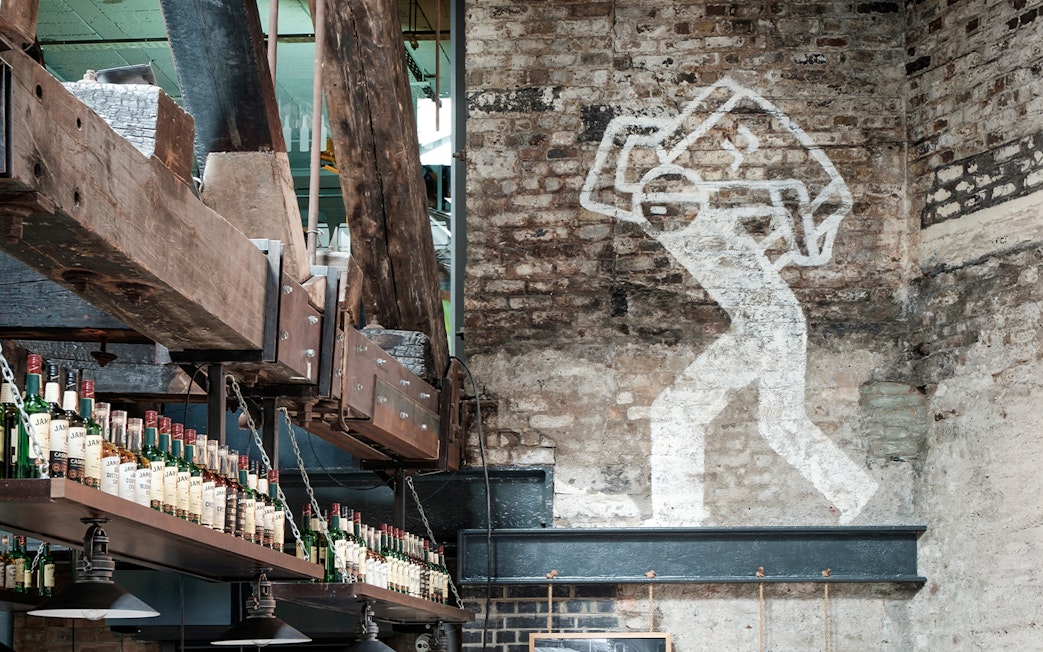 Jameson Distillery interior with whiskey bottles and industrial decor.