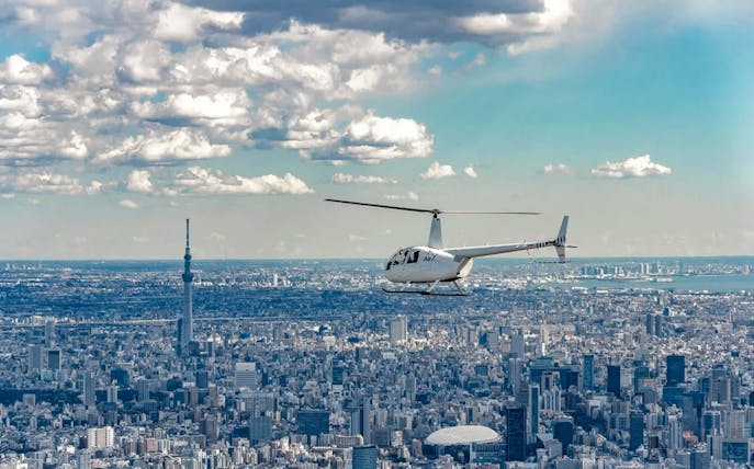 Helicopter flying over Tokyo cityscape with Tokyo Skytree in view.